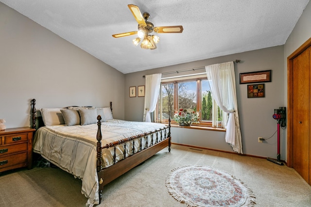 carpeted bedroom featuring lofted ceiling, a textured ceiling, baseboards, and ceiling fan