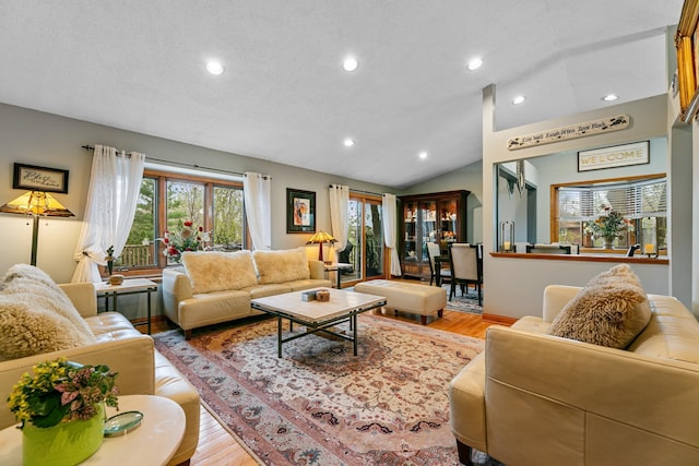 living room featuring light wood finished floors, recessed lighting, vaulted ceiling, and baseboards