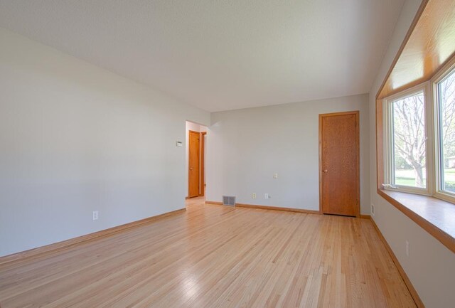 unfurnished room with light wood-style floors and baseboards