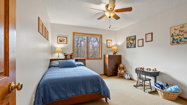 carpeted bedroom featuring a textured ceiling, baseboards, and a ceiling fan