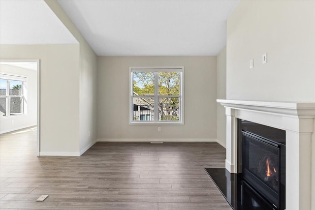 983 Aurora Cir, Red Wing, MN 55066 - unfurnished living room with a glass covered fireplace, wood finished floors, and baseboards