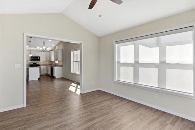 983 Aurora Cir, Red Wing, MN 55066 - unfurnished living room featuring lofted ceiling, a chandelier, ceiling fan, dark wood-style floors, and baseboards