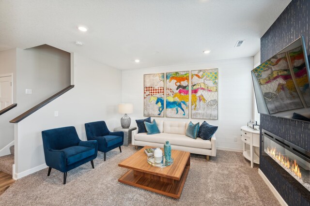 living room with stairs, baseboards, carpet flooring, a glass covered fireplace, and recessed lighting
