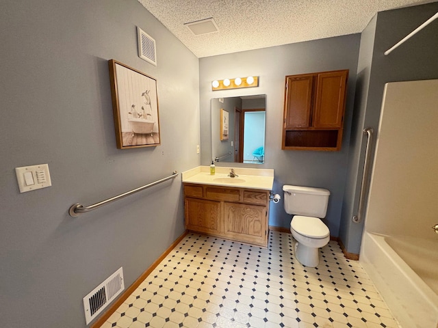 bathroom featuring baseboards, toilet, vanity, a textured ceiling, and shower / bathtub combination