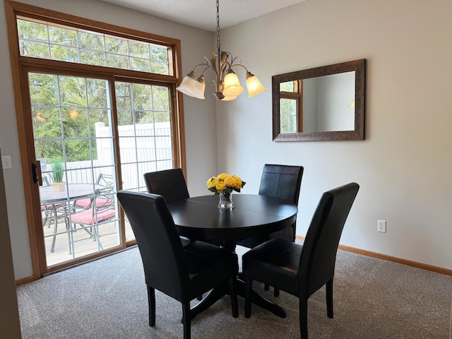 dining area with a chandelier, carpet floors, baseboards, and a textured ceiling