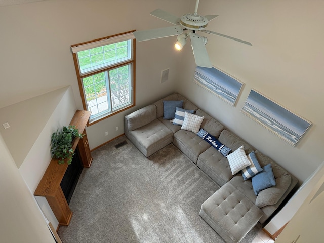 carpeted living area featuring a ceiling fan and baseboards
