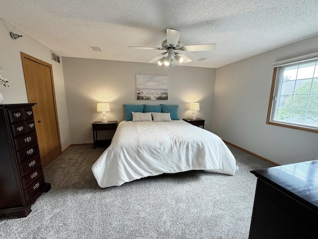 carpeted bedroom featuring a textured ceiling, a ceiling fan, and baseboards