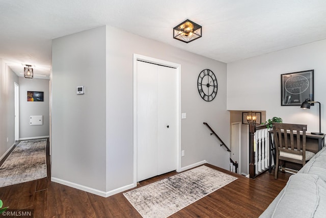 entrance foyer featuring a chandelier, wood finished floors, and baseboards