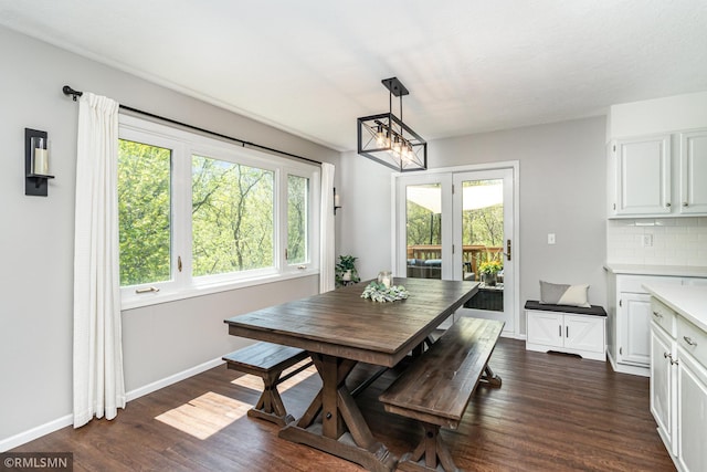 dining room with plenty of natural light, dark wood-style floors, a chandelier, and baseboards
