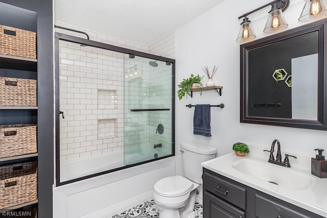 bathroom featuring vanity, toilet, and shower / bath combination with glass door