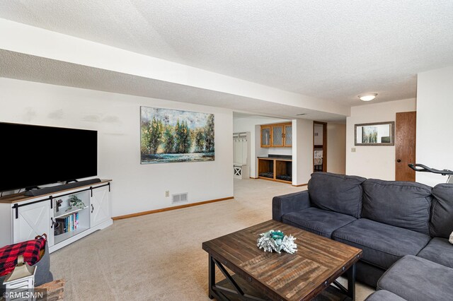 living area with light carpet, baseboards, and a textured ceiling