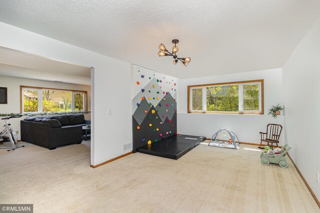 game room with carpet floors, a chandelier, plenty of natural light, and baseboards