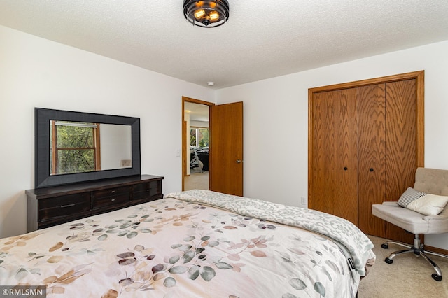 carpeted bedroom with a closet and a textured ceiling