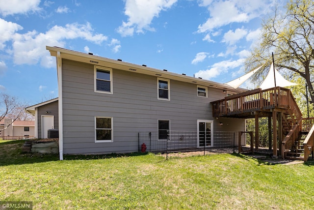 rear view of property featuring a wooden deck, stairway, and a lawn
