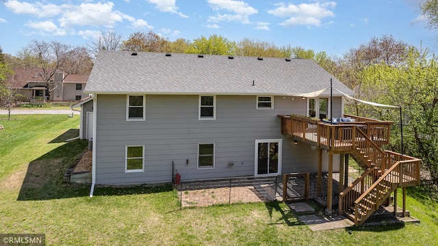 back of property with a wooden deck, stairs, a lawn, and a shingled roof