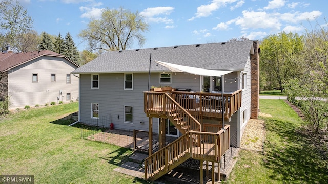 back of house featuring stairway, a deck, roof with shingles, and a lawn
