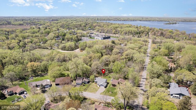 aerial overview of property's location featuring a heavily wooded area, a nearby body of water, and nearby suburban area