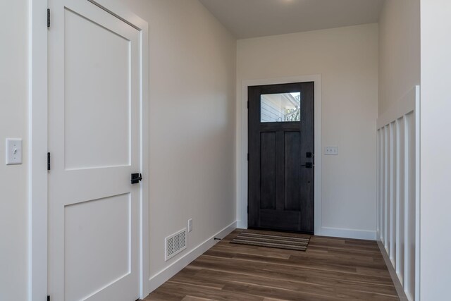 entryway with dark wood finished floors, visible vents, and baseboards
