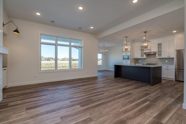 kitchen with stainless steel appliances, a chandelier, baseboards, white cabinetry, and recessed lighting