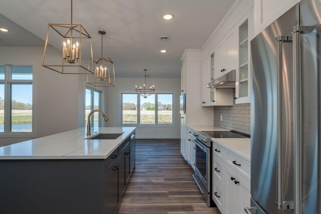 kitchen with appliances with stainless steel finishes, a sink, a chandelier, a kitchen island with sink, and recessed lighting