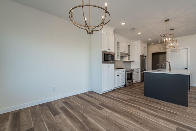 kitchen with recessed lighting, an inviting chandelier, a sink, dark wood-type flooring, and appliances with stainless steel finishes