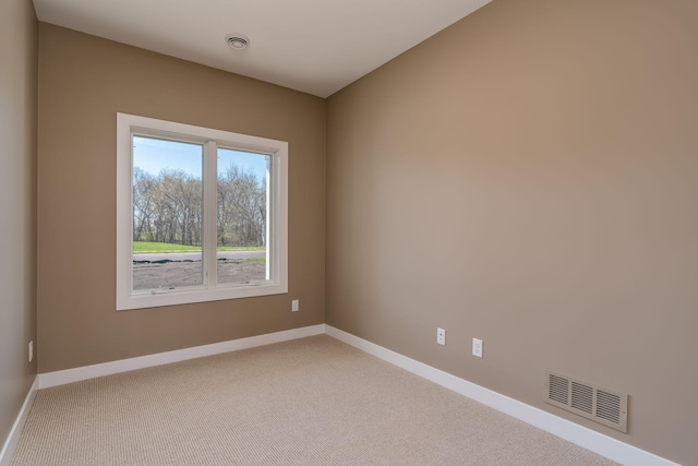 spare room featuring baseboards and light carpet