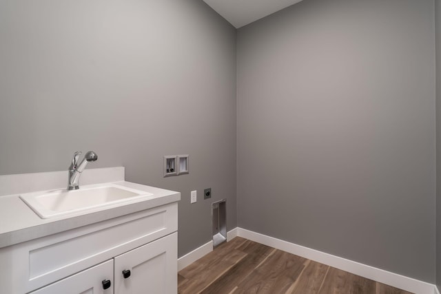 washroom with electric dryer hookup, cabinet space, washer hookup, baseboards, and dark wood-type flooring