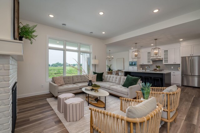 2132 Deerwood Dr, North Mankato, MN 56003 - living area with a fireplace, dark wood-style flooring, recessed lighting, and a chandelier