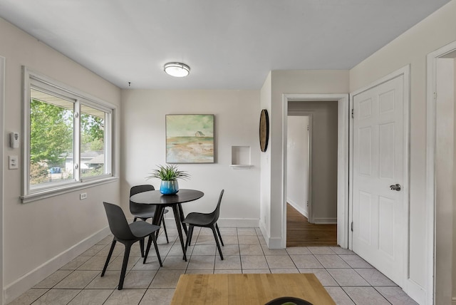 dining area featuring light tile patterned flooring and baseboards