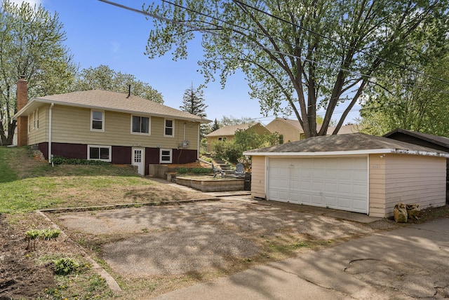 view of front of home with a detached garage, an outdoor structure, and a chimney