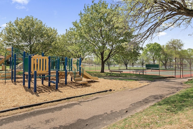 communal playground with a tennis court and fence