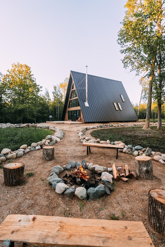 21574 State 200, Rice Twp, MN 56621 - back of property with metal roof, a standing seam roof, and an outdoor fire pit