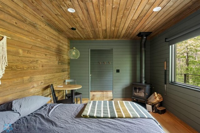 21574 State 200, Rice Twp, MN 56621 - bedroom featuring wooden ceiling, a wood stove, wood walls, recessed lighting, and wood finished floors