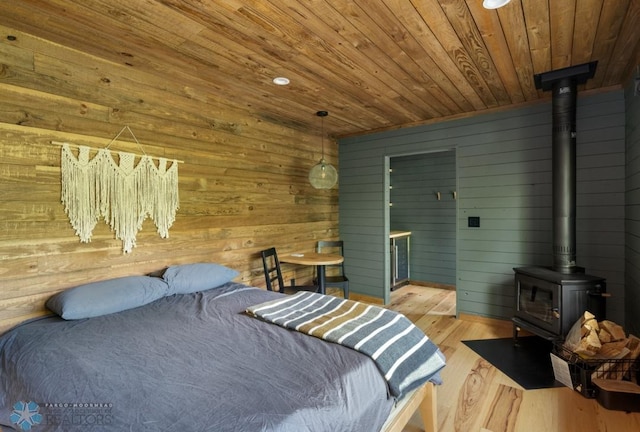 21574 State 200, Rice Twp, MN 56621 - bedroom featuring a wood stove, wooden ceiling, wooden walls, wood finished floors, and ensuite bathroom