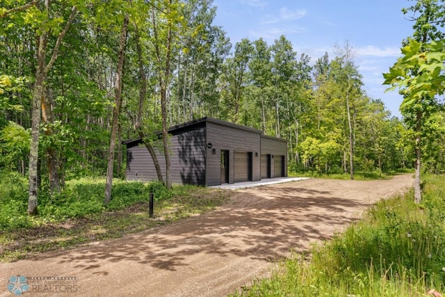 21574 State 200, Rice Twp, MN 56621 - view of home's community featuring a garage, dirt driveway, and an outbuilding