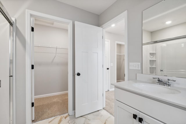 6746 Wildflower Way, Minnetrista, MN 55331 - bathroom featuring marble finish flooring, a walk in closet, vanity, a shower with shower door, and recessed lighting