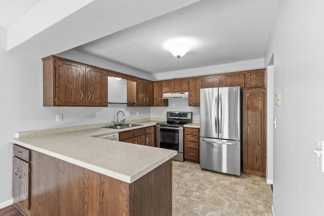 kitchen featuring appliances with stainless steel finishes, a sink, exhaust hood, a peninsula, and light countertops