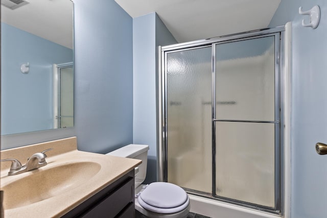 full bath with a stall shower, toilet, and vanity