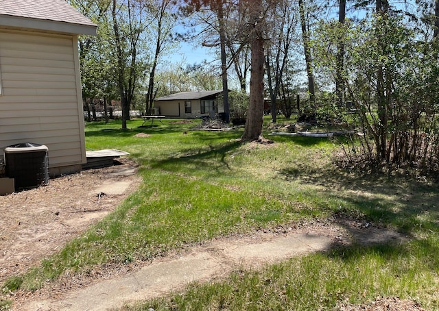 view of grassy yard featuring central AC