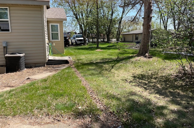 view of grassy yard with central air condition unit