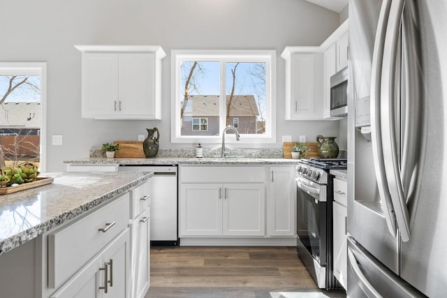 kitchen with a sink, dark wood-style flooring, white cabinets, and appliances with stainless steel finishes
