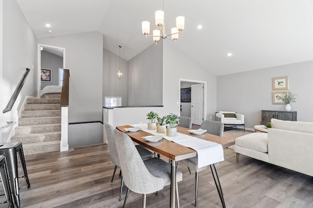 dining space featuring recessed lighting, an inviting chandelier, stairs, high vaulted ceiling, and wood finished floors