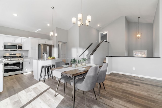 dining area with light wood-type flooring, recessed lighting, a notable chandelier, and high vaulted ceiling