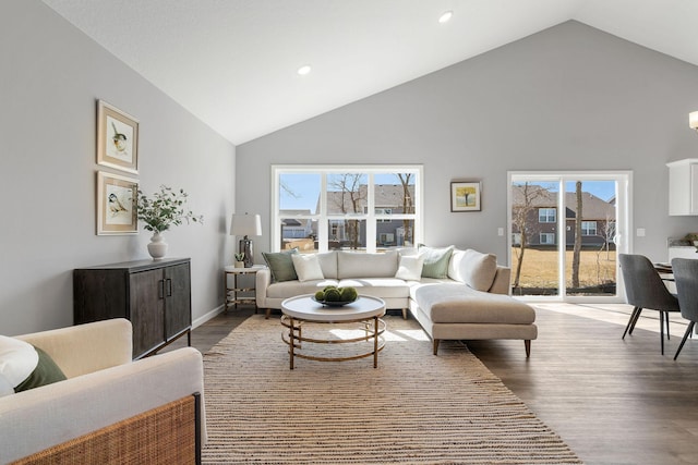 living area featuring a wealth of natural light, recessed lighting, high vaulted ceiling, and wood finished floors