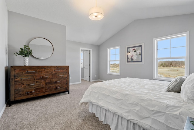 carpeted bedroom featuring baseboards and vaulted ceiling