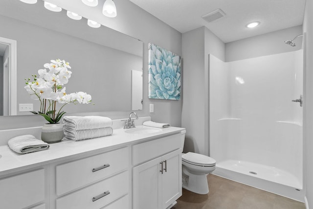 full bath with a stall shower, vanity, and toilet