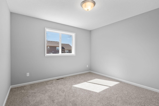 spare room with visible vents, baseboards, and carpet floors