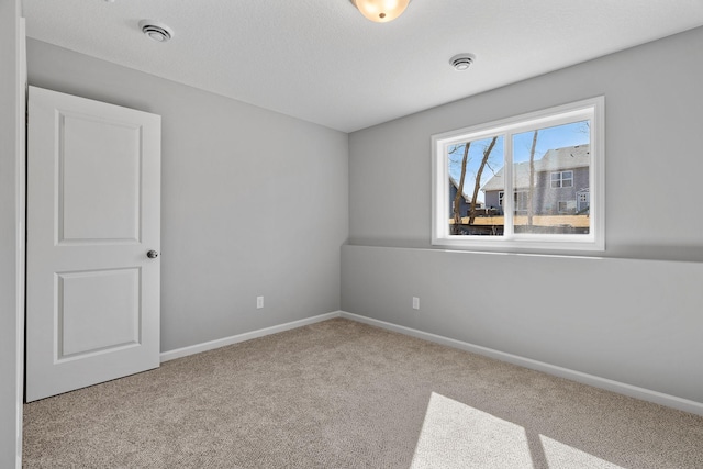 carpeted empty room featuring baseboards