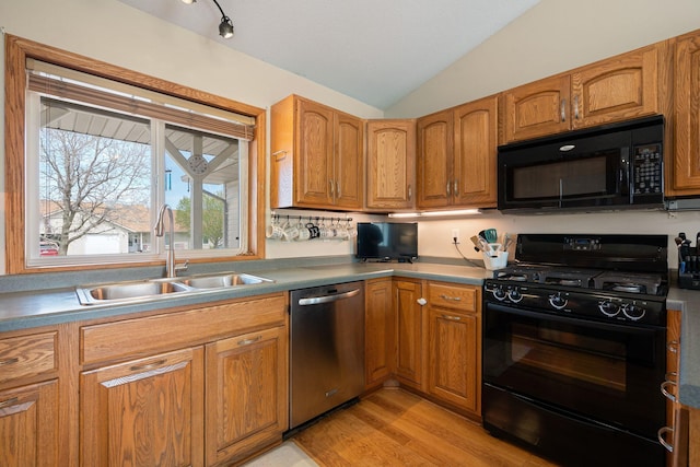 404 6th St NW, New Richland, MN 56072 - kitchen with black appliances, a sink, lofted ceiling, light wood-style flooring, and brown cabinetry
