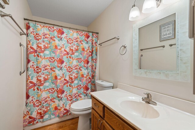 404 6th St NW, New Richland, MN 56072 - full bath featuring toilet, vanity, curtained shower, and wood finished floors